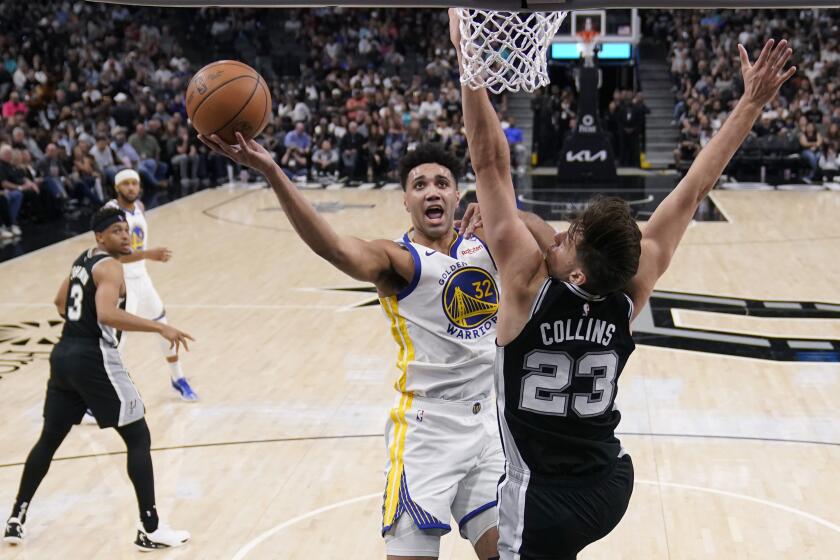 Golden State Warriors forward Trayce Jackson-Davis (32) drives to the basket against San Antonio Spurs forward Zach Collins (23) during the second half of an NBA basketball game in San Antonio, Monday, March 11, 2024. (AP Photo/Eric Gay)
