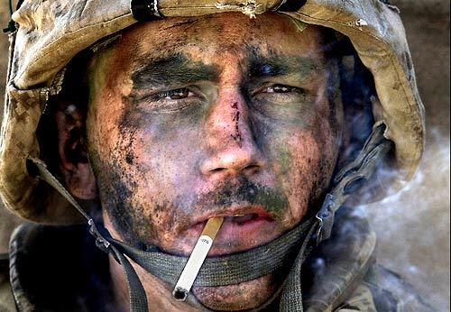 As a Marine Corps lance corporal, Blake Miller was with the 1st Marine Battalion, 8th Regiment, during the assault on the insurgent stronghold of Fallouja, Iraq, in November, 2004, when this picture was taken. Filthy and exhausted, he had just lighted a cigarette when an embedded photographer captured this image, which transformed Miller into an icon of the war in Iraq. He now suffers from post-traumatic stress disorder.
