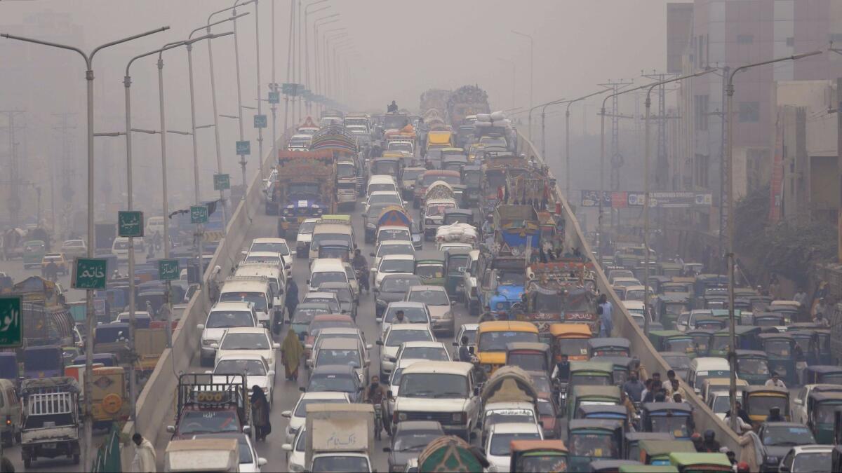 Vehicles drive in heavy smog on the outskirts of Peshawar, Pakistan.