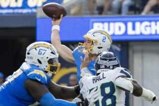 Chargers quarterback Easton Stick is pressured by Seattle Seahawks linebacker Derick Hall in their preseason game.