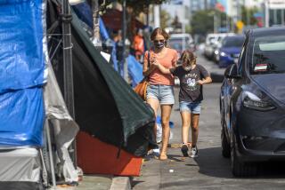 LOS ANGELES, CA - AUGUST 30: After school, Michelle Baron, walks with her daughter Penelope Baron past a homeless encampment near Larchmont Charter School - Selma located in the Hollywood neighborhood on Monday, Aug. 30, 2021 in Los Angeles, CA. The street becomes congested with vehicles as families arrive to pick up their children. Because the sidewalk is blocked with tents families and students end up walking in the street past the tents in between cars. (Francine Orr / Los Angeles Times)