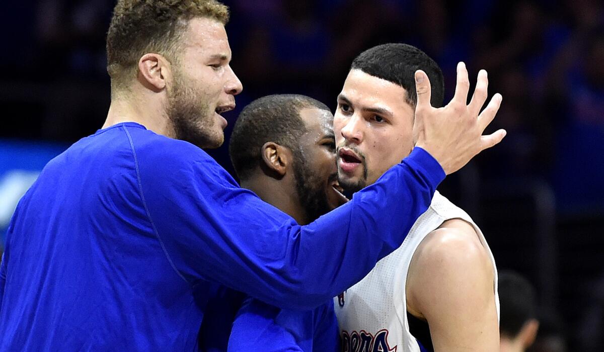 Clippers forward Blake Griffin, left, and guard Chris Paul, center, come off the bench to hug Austin Rivers at the end of the third quarter during Game 3 on Friday night.