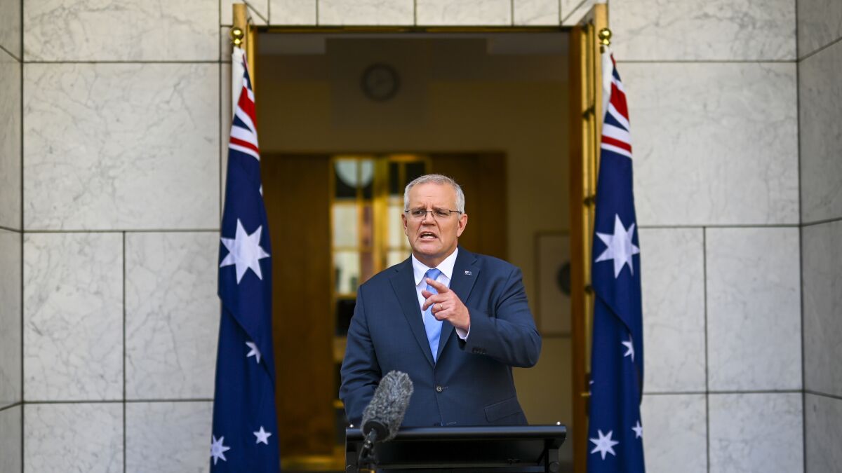 Australian Prime Minister Scott Morrison gestures during a news conference at Parliament House in Canberra, Australia, Sunday, April 10, 2022. Morrison has called for a May 21 election that will be fought on issues including Chinese economic coercion, climate change and the COVID-19 pandemic. (Lukas Coch/AAP Image via AP)