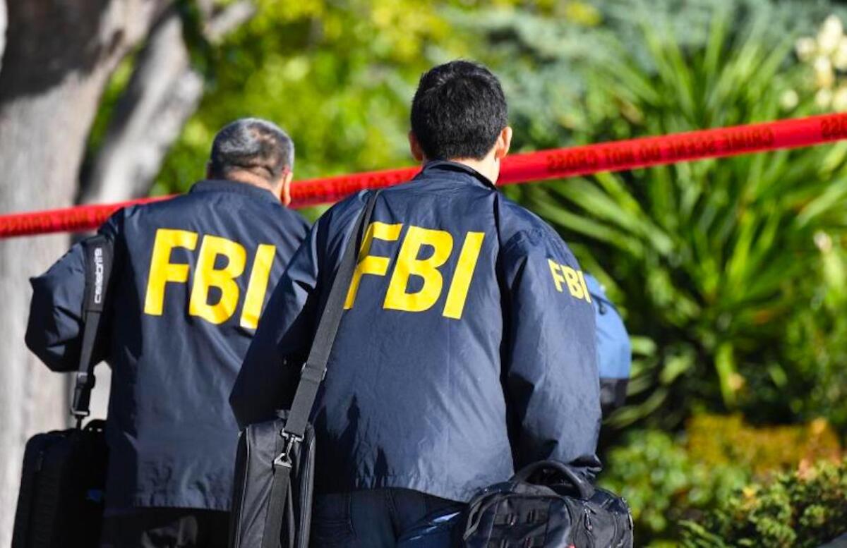 Two men wear "FBI"-branded windbreakers.