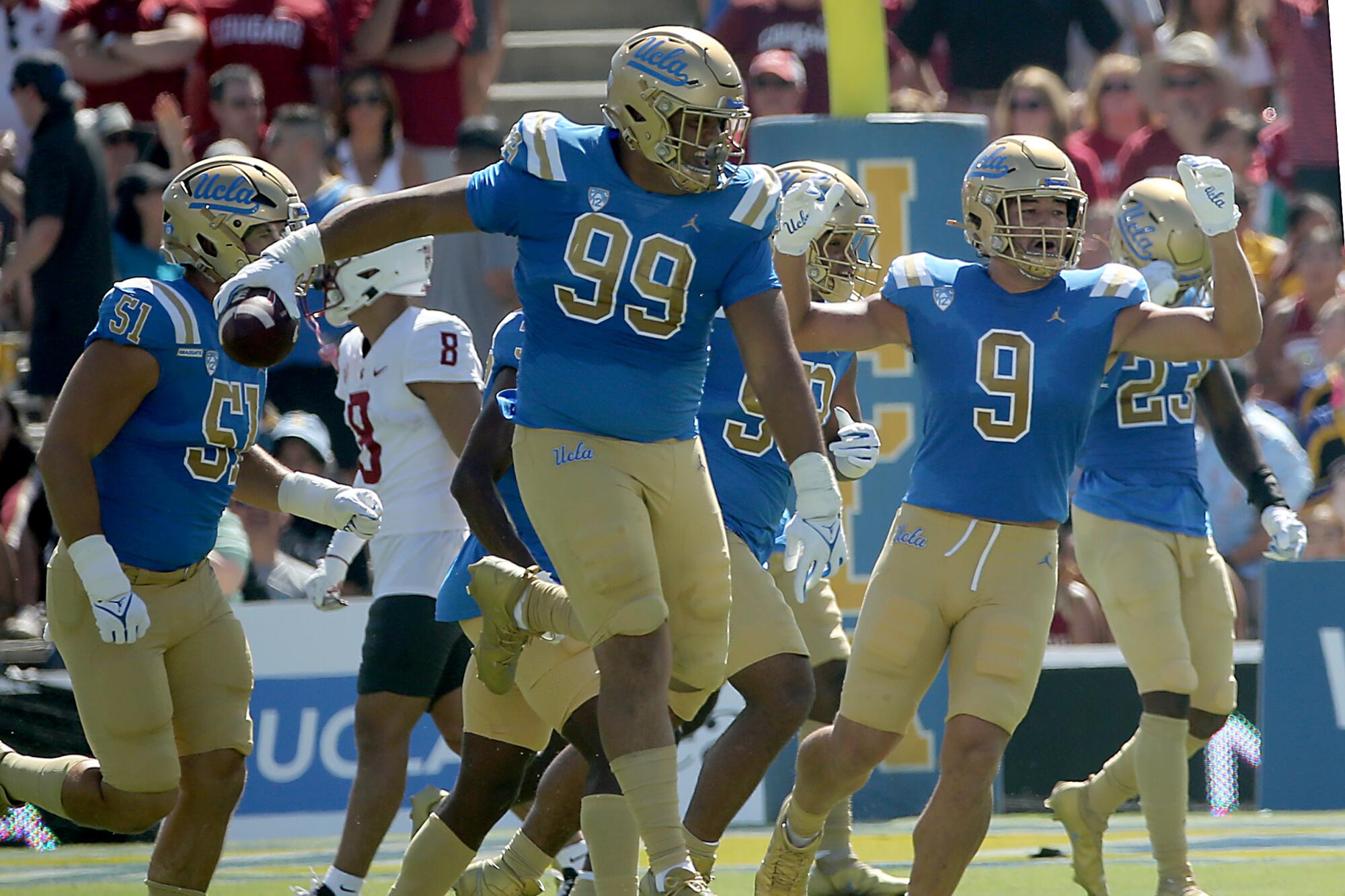 UCLA defensive lineman Keanu Williams (99) celebrates after recovering a fumble by Washington State's Cameron Williams.