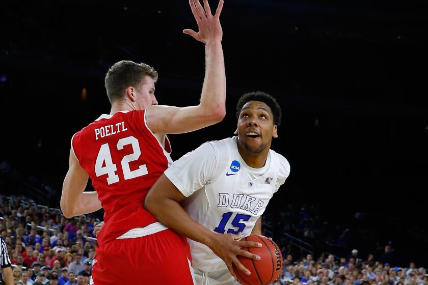 Duke center Jahlil Okafor powers his way past Utah center Jakob Poeltl during the Blue Devils' victory in the South Regional semifinal game Friday night.