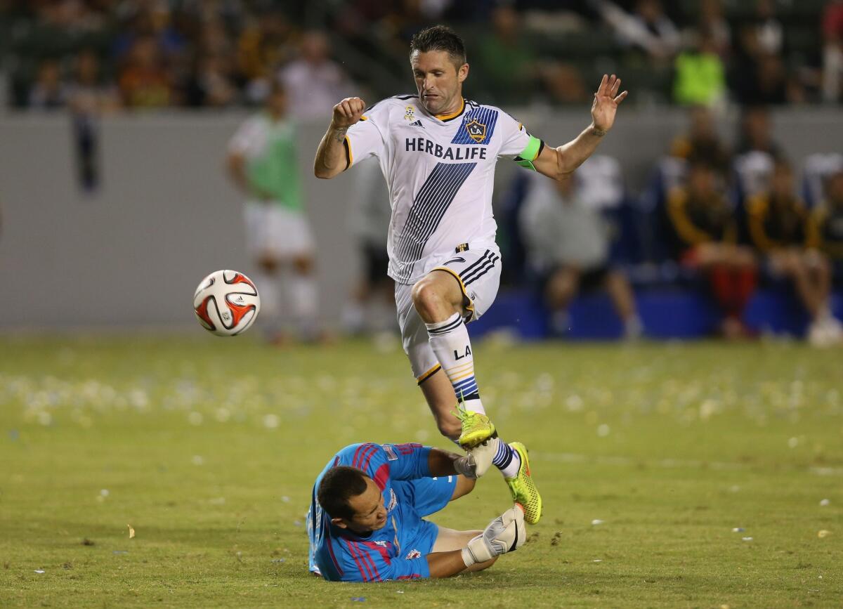 New York Red Buills goal keeper Luis Robles makes a save on the Galaxy's Robbie Keane during a match on Sept. 28.