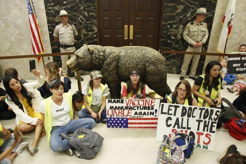 Opponents of a measure that would give public health officials oversight of doctors that may be giving fraudulent medical exemptions from vaccinations during gathered in front of the governor's office after it was approved by the Assembly Health Committee at the Capitol in Sacramento, Calif., Thursday, June 20, 2019.(AP Photo/Rich Pedroncelli)
