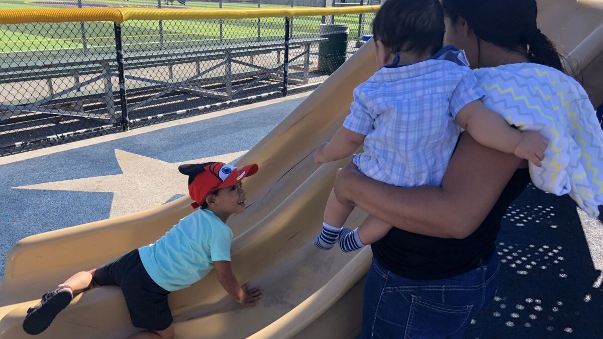 Claudia Calderon plays with her her sons, Andriy, 3, and Adrian, seven months, at a park in Van Nuys. Andriy was separated from his father when they were attempting to enter the United States from Guatemala.
