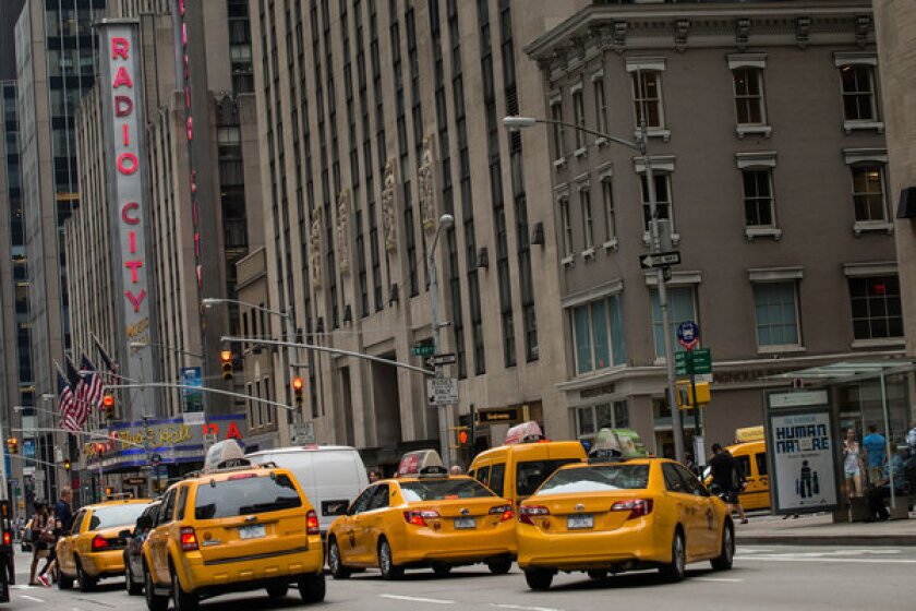 Taxis drive New York's Avenue of the Americas in June.