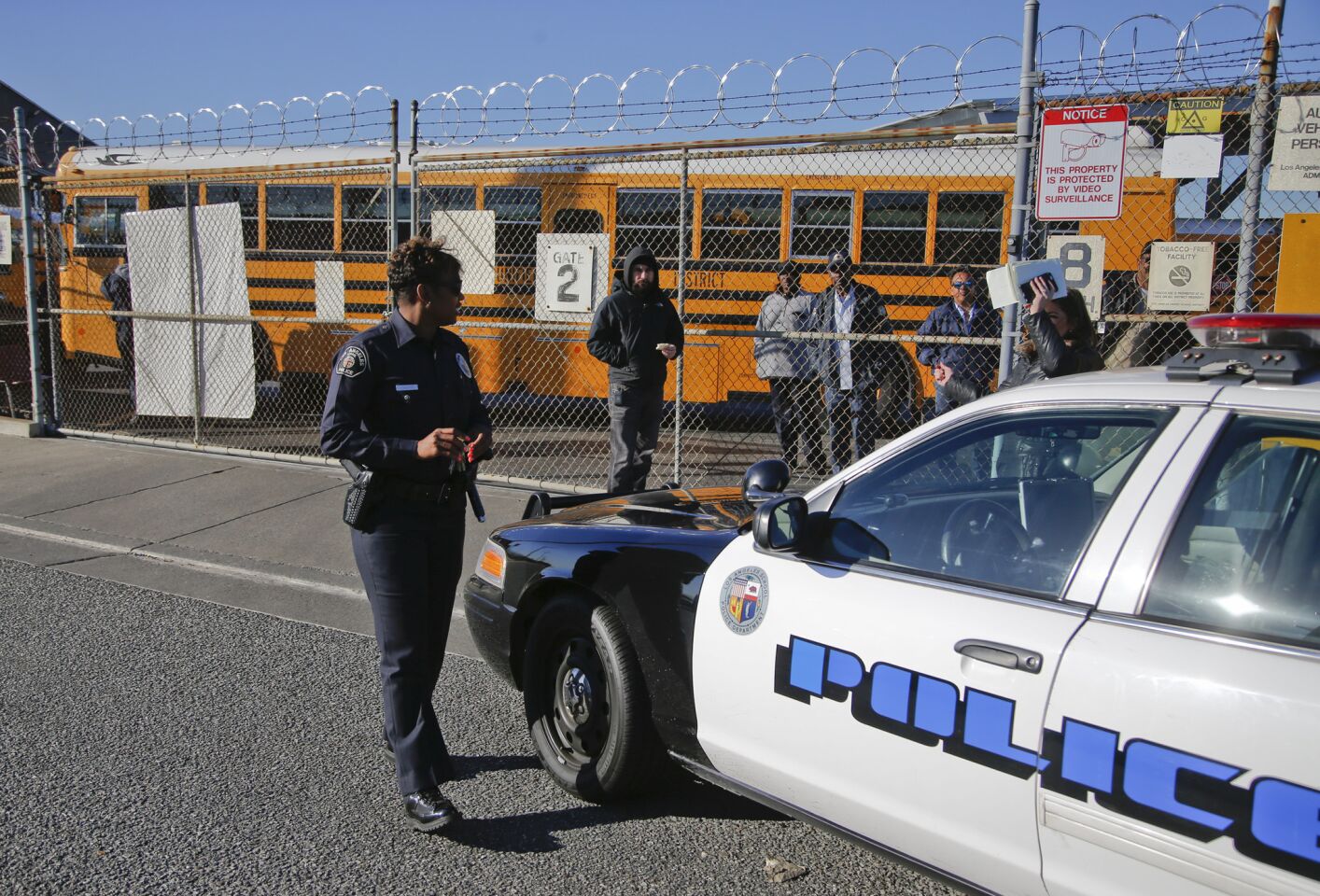 A Los Angeles School Police officer checks in with officials at the LAUSD's Gardena garage, where school buses are parked Dec. 15 as officials investigate a threat against the district.