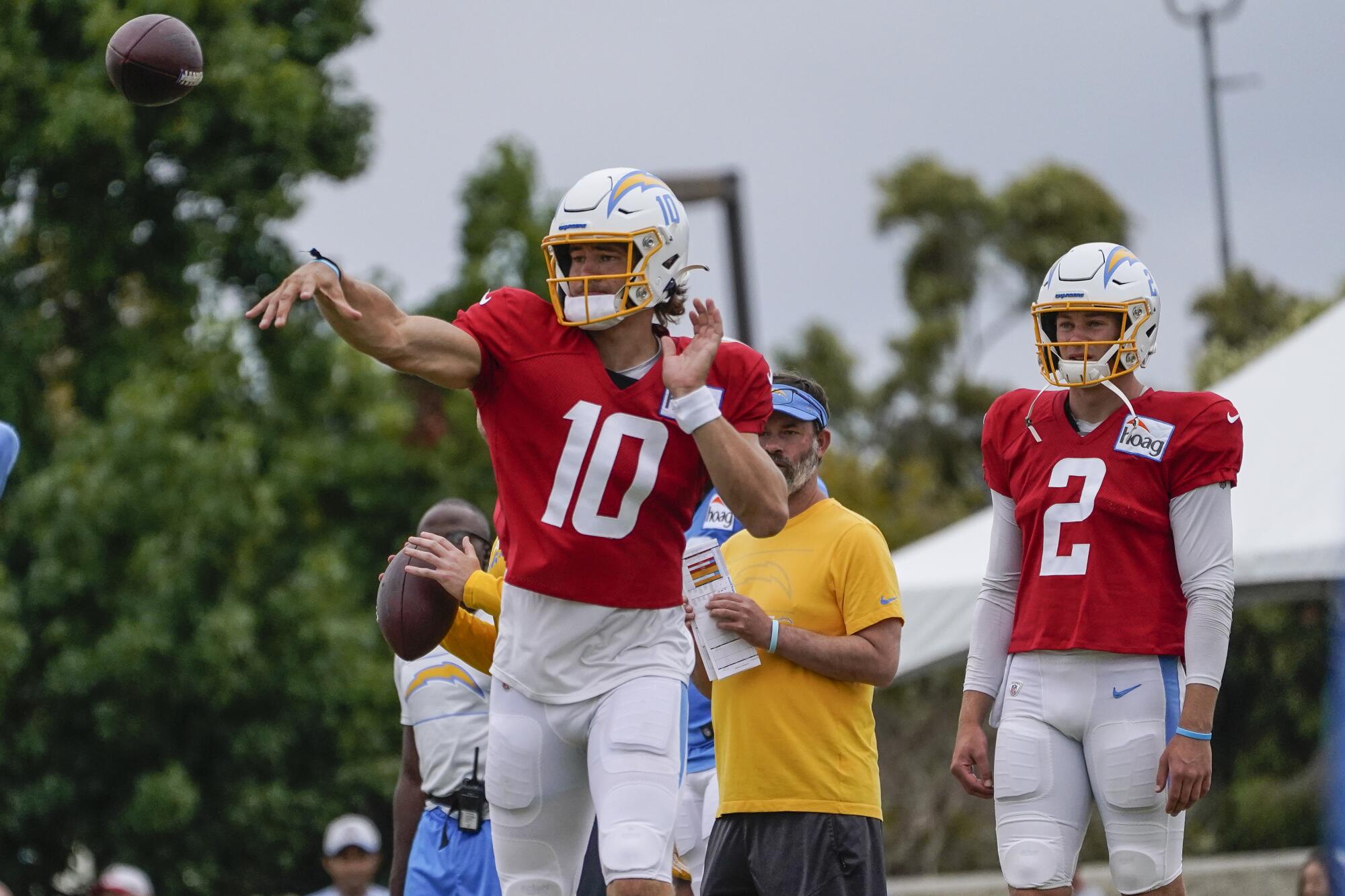 Chargers quarterback Justin Herbert throws as Easton Stick watches.