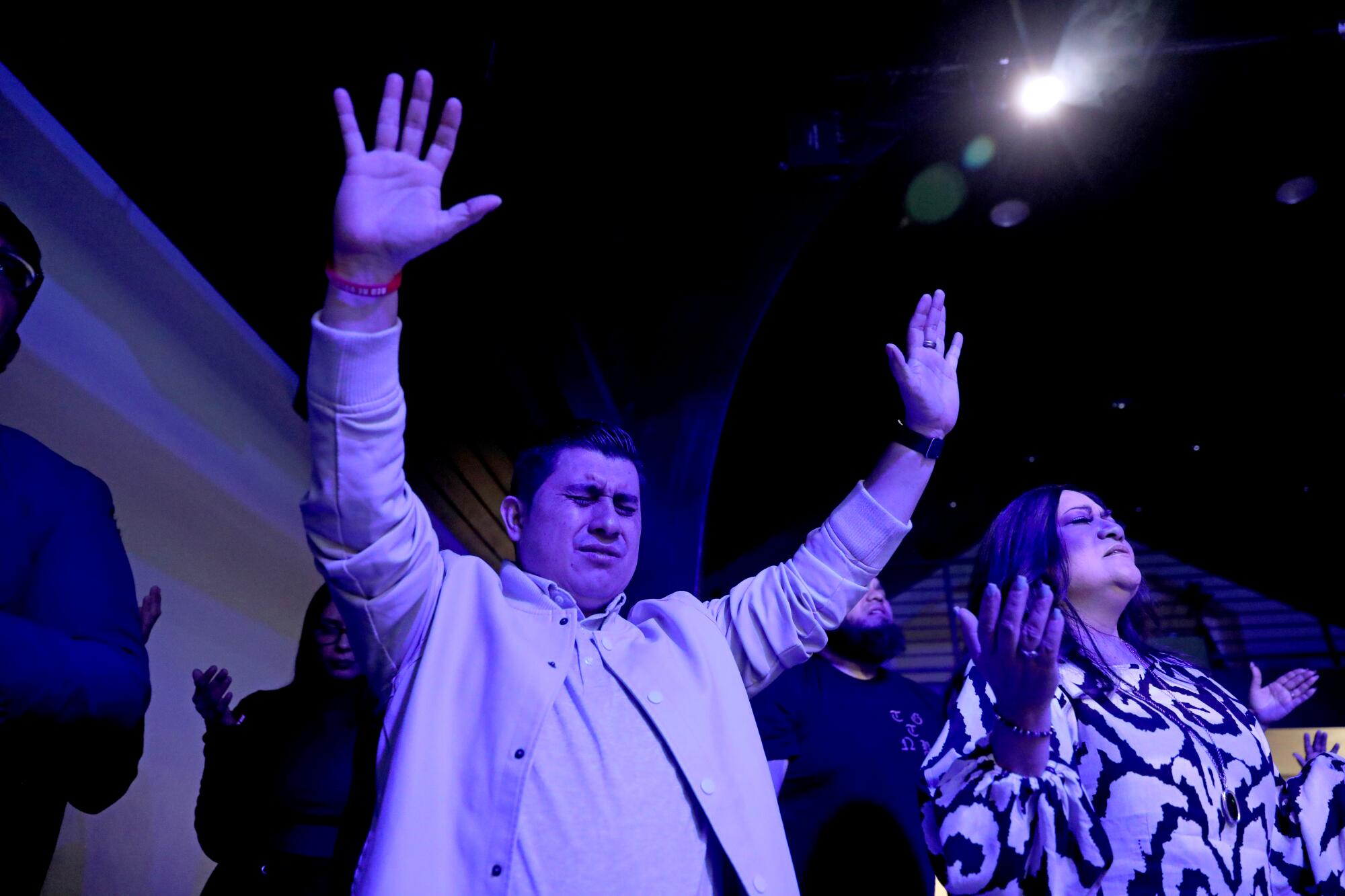 A man raises his arms next to a woman holding up her hands 