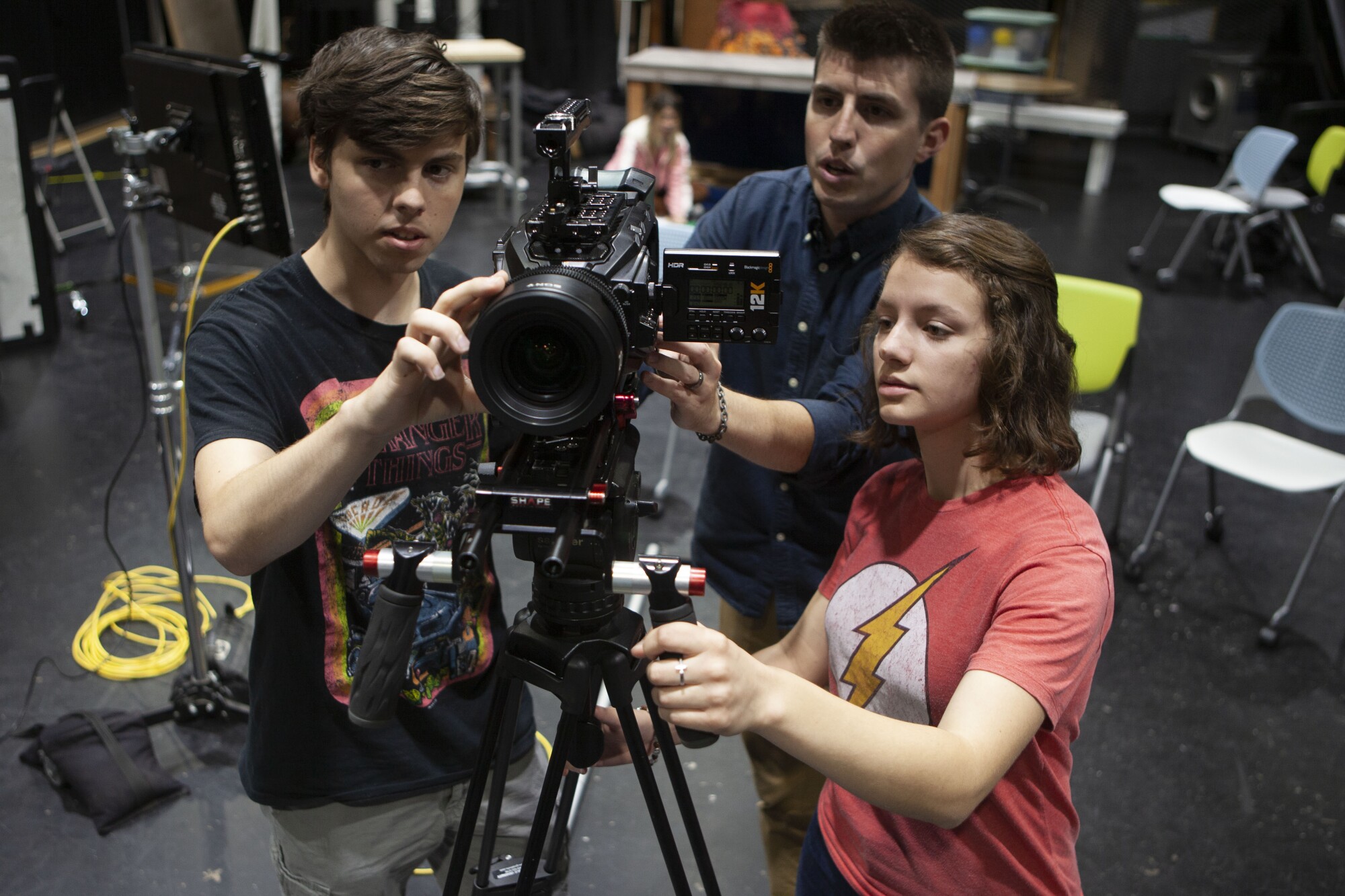 George Simon, center, teaches students how to use a movie camera.