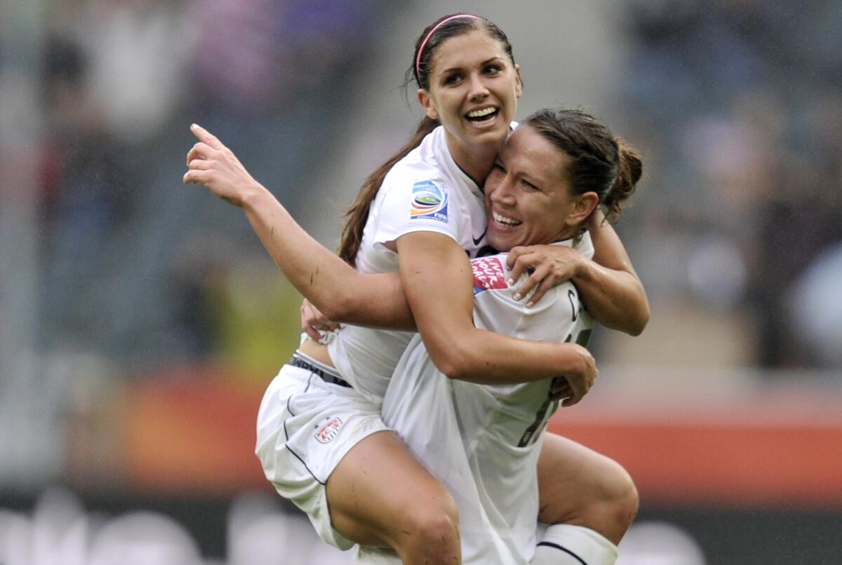 Alex Morgan is carried by U.S. teammate Lauren Cheney scoring against France during the 2011 Women's World Cup semifinals in Moenchengladbach, Germany.