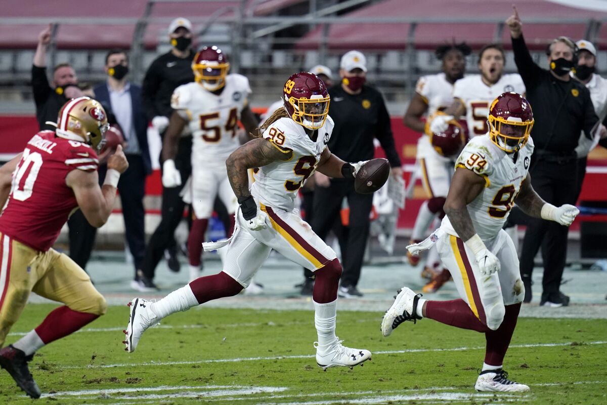 Washington Football Team defensive end Chase Young (99) runs back a fumble recovery for a touchdown against the San Francisco 49ers during the first half of an NFL football game, Sunday, Dec. 13, 2020, in Glendale, Ariz. (AP Photo/Ross D. Franklin)