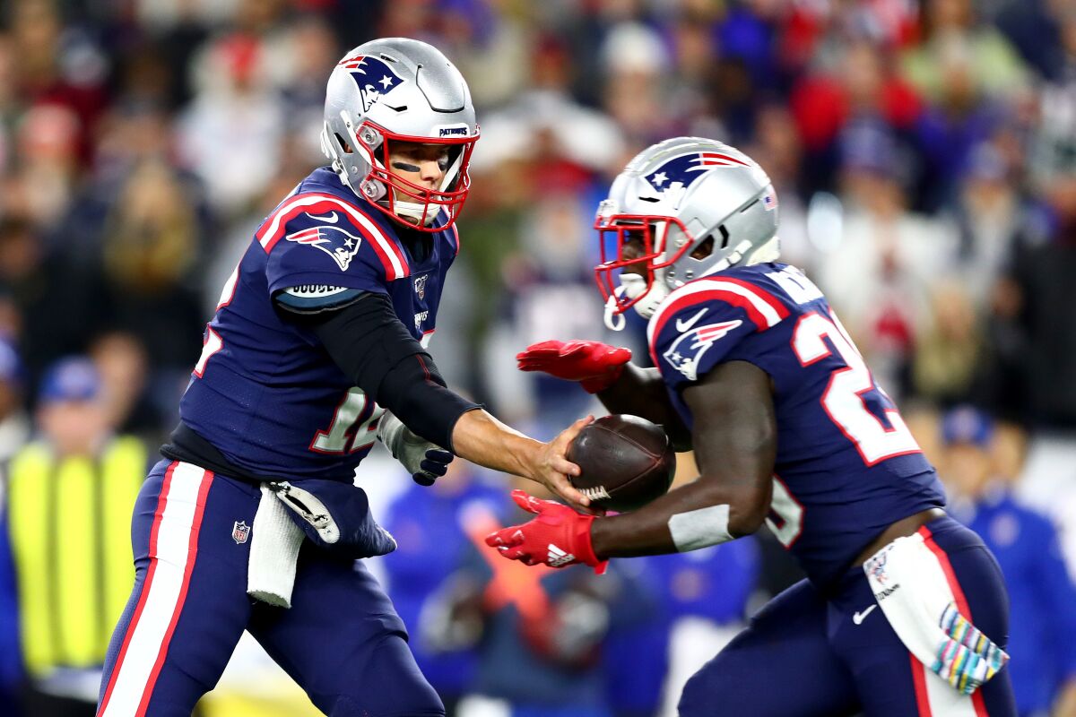 New England Patriots quarterback Tom Brady, left, hands the ball off to running back Sony Michel against the New York Giants during the first quarter on Thursday in Foxborough, Mass.