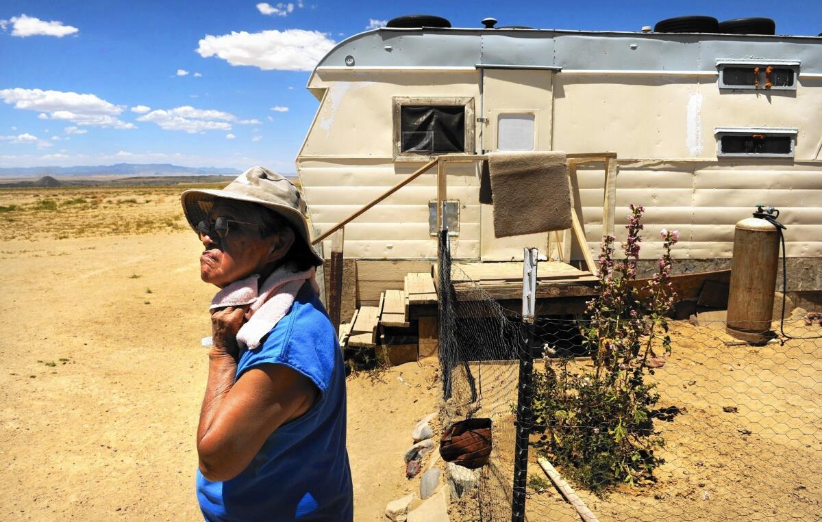 Cynthia Dixon outside her trailer in Fruitland, N.M. Dixon lives near a coal mine and the Four Corners electrical plant, which she blames for health problems. She wants to leave. “But where can I go?”