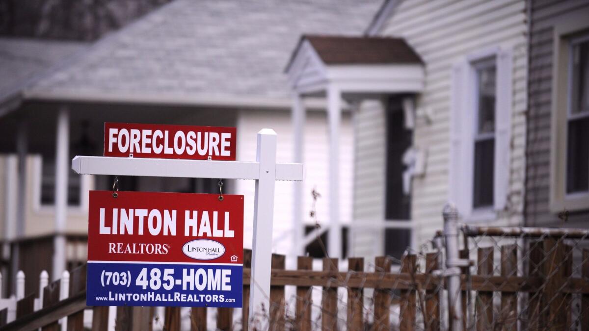 A foreclosure sign is posted in the front of a house in Alexandria, Va., in December 2008. (SHAWN THEW / EPA)