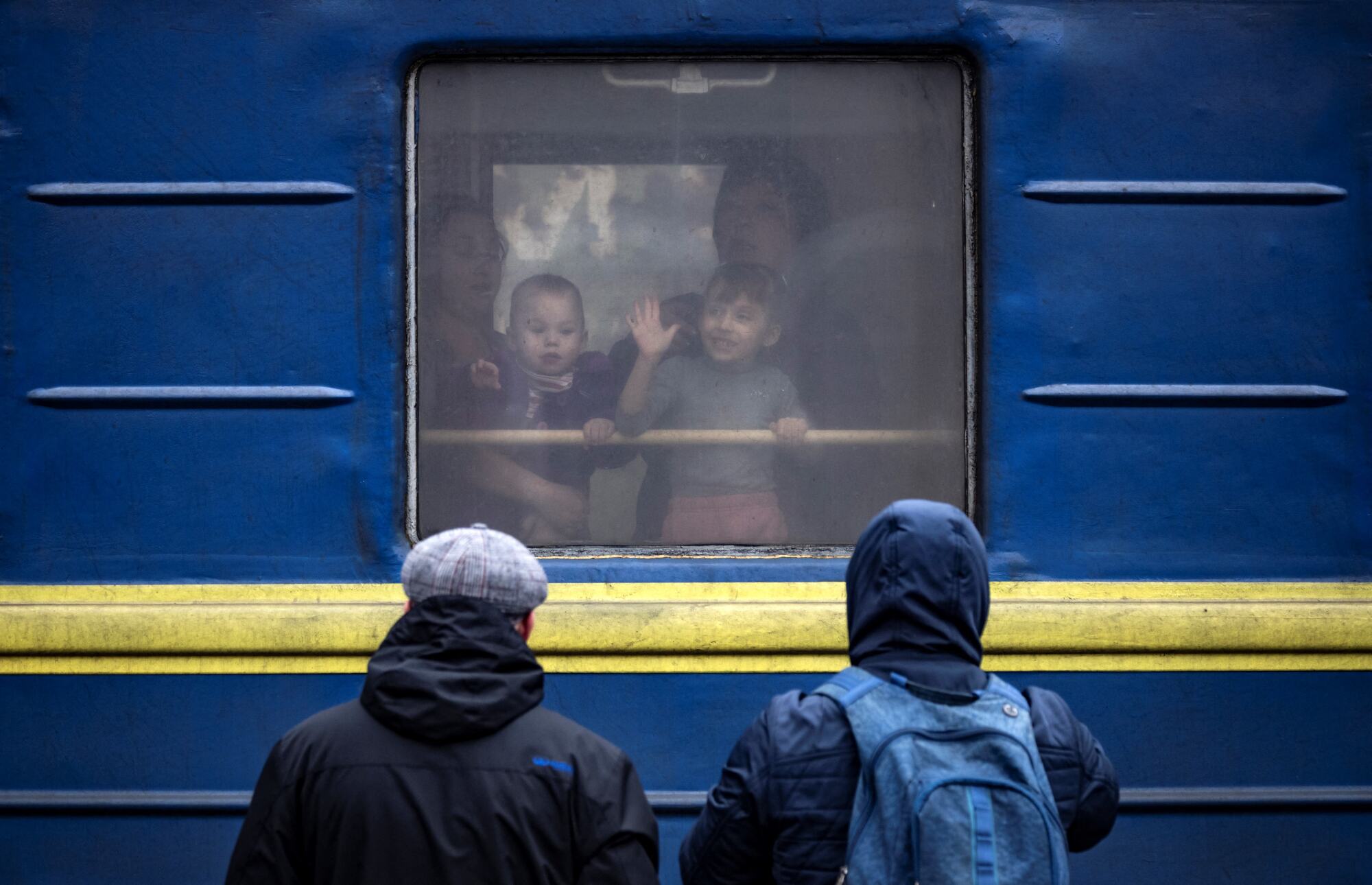 Children wave at people from a train at Kramatorsk central station