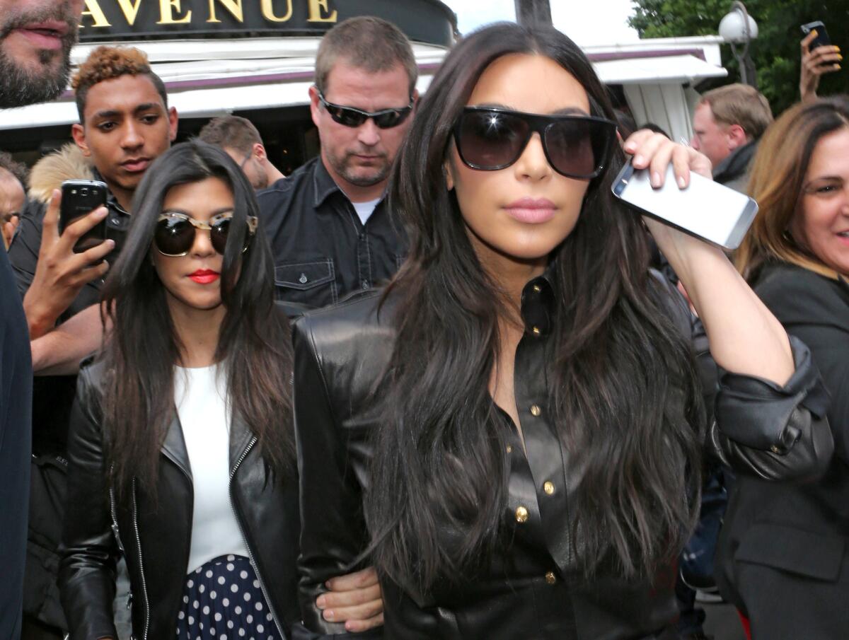 Kim Kardashian, front, and Kourtney Kardashian, left, leave a restaurant in Paris on Thursday.
