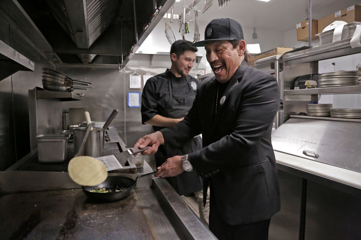 Actor Danny Trejo, right, and chef John-Carlos Kuramoto cook up their vegan cauliflower taco at Trejo's Cantina in Hollywood.