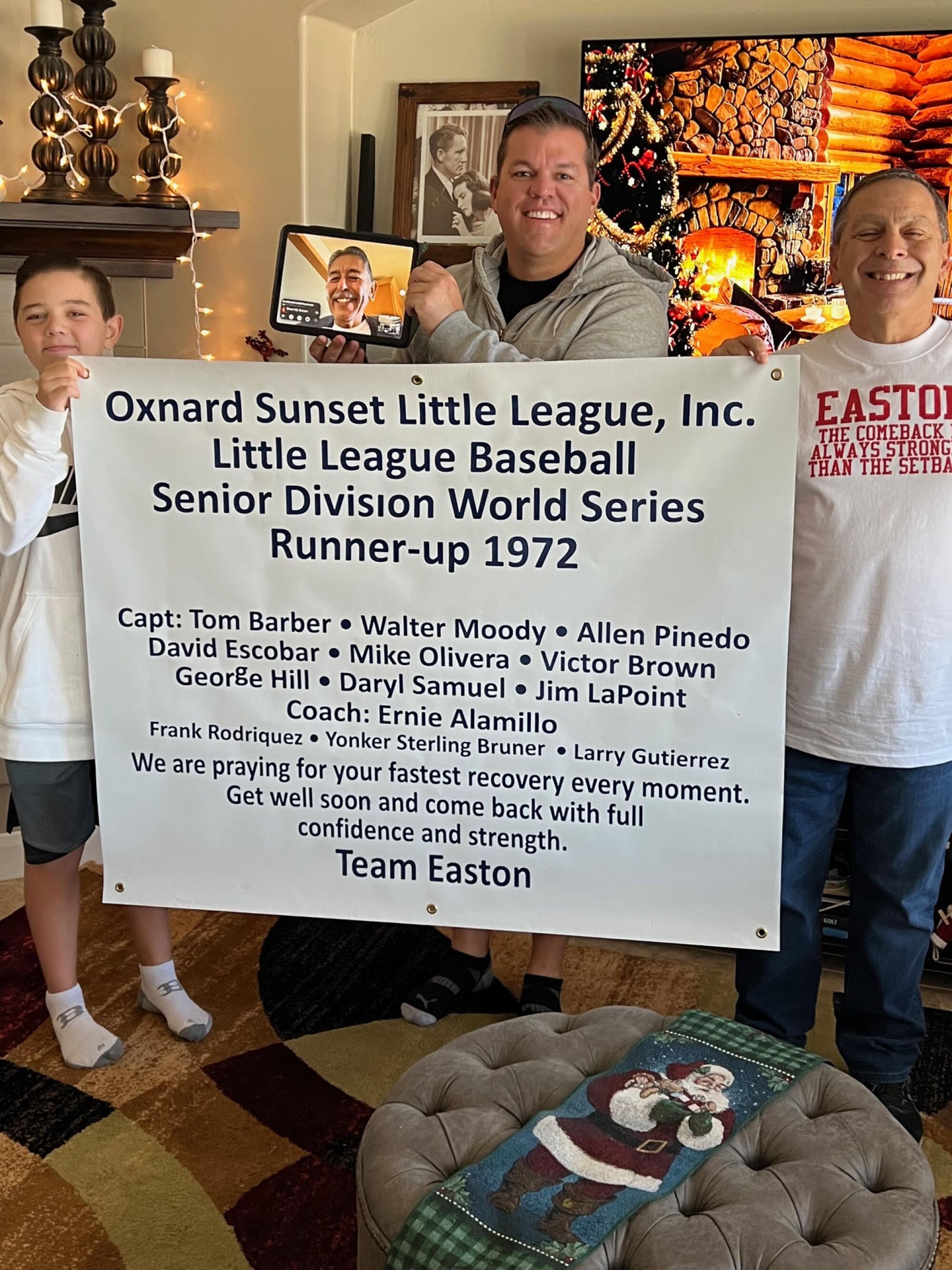 Easton Oliverson is next to his dad Jace, who has a tablet with Buddy Salinas on it, and holding a banner with Frank Randazzo