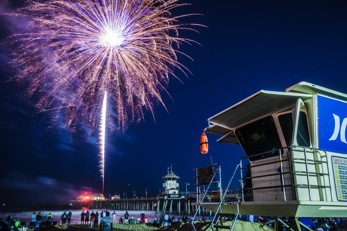 Spectators watch the Fourth of July fireworks show over the Huntington Beach Pier in 2019.