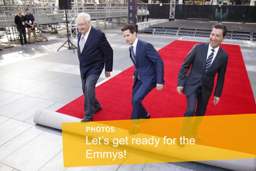 Andy Samberg, host of the 2015 Emmy Awards, center, rolls out the red carpet with executive producer Don Mischer, left, and Television Academy Chairman/CEO Bruce Rosenblum during a press preview three days before the show.