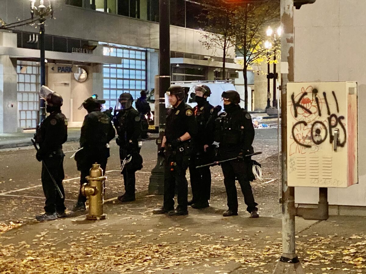 Portland police officers wait for anarchists who set a fire to make their next move.