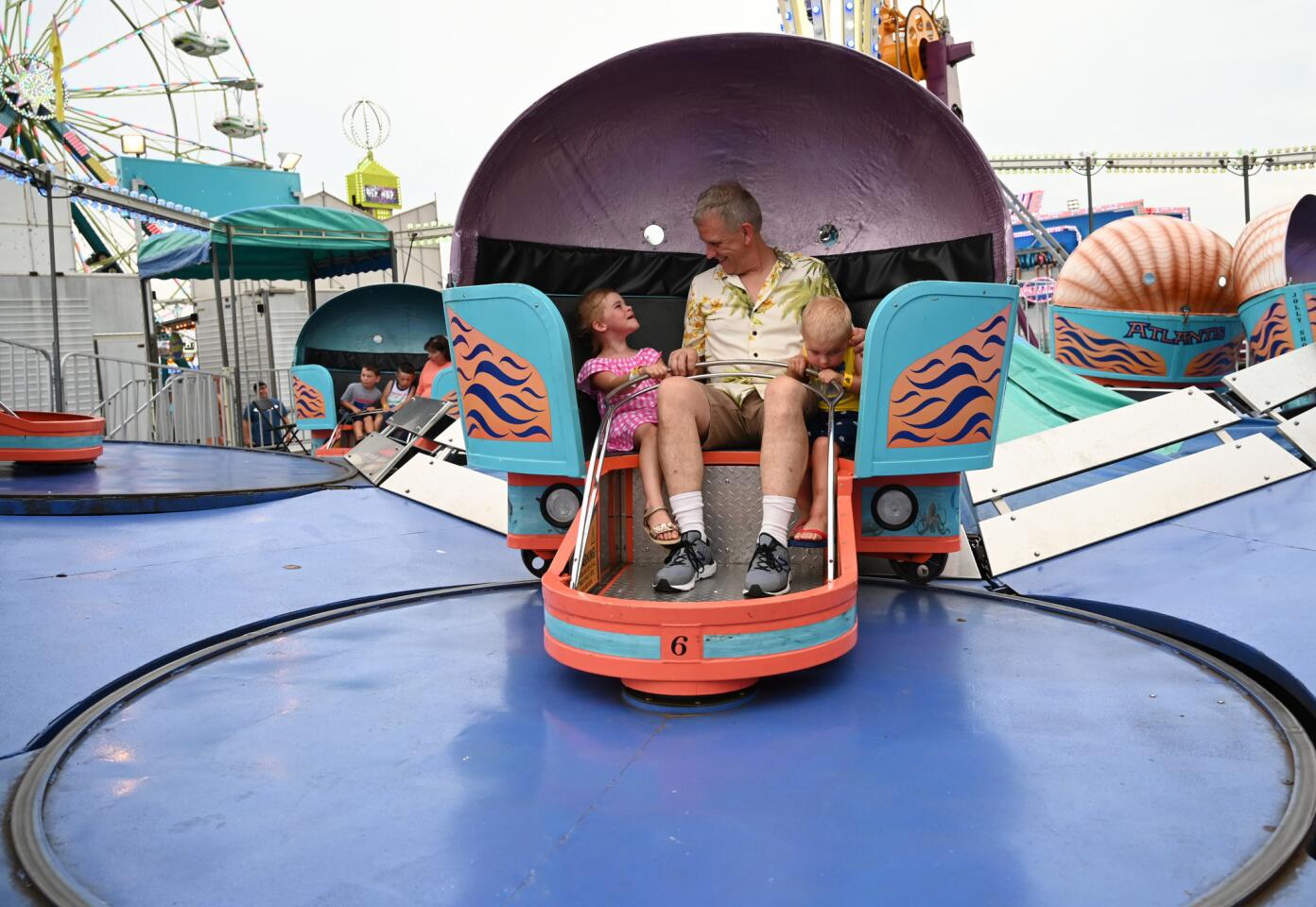 Dan Summerhill of Hampstead enjoys a ride with his grandchildren Emma and Conor during the carnival at Reese & Community Volunteer Fire Company on Tuesday, July 16.