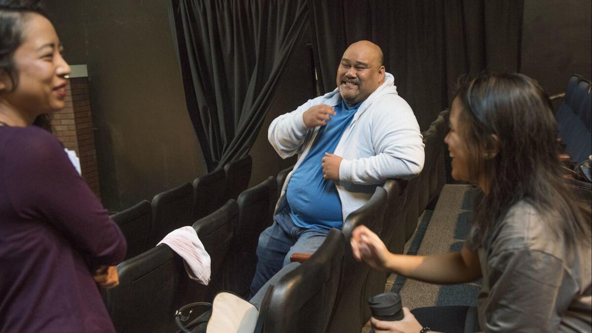 Playwright Boni B. Alvarez talks with "America Adjacent" cast members Arianne Villareal, left, and Samantha Valdellon.