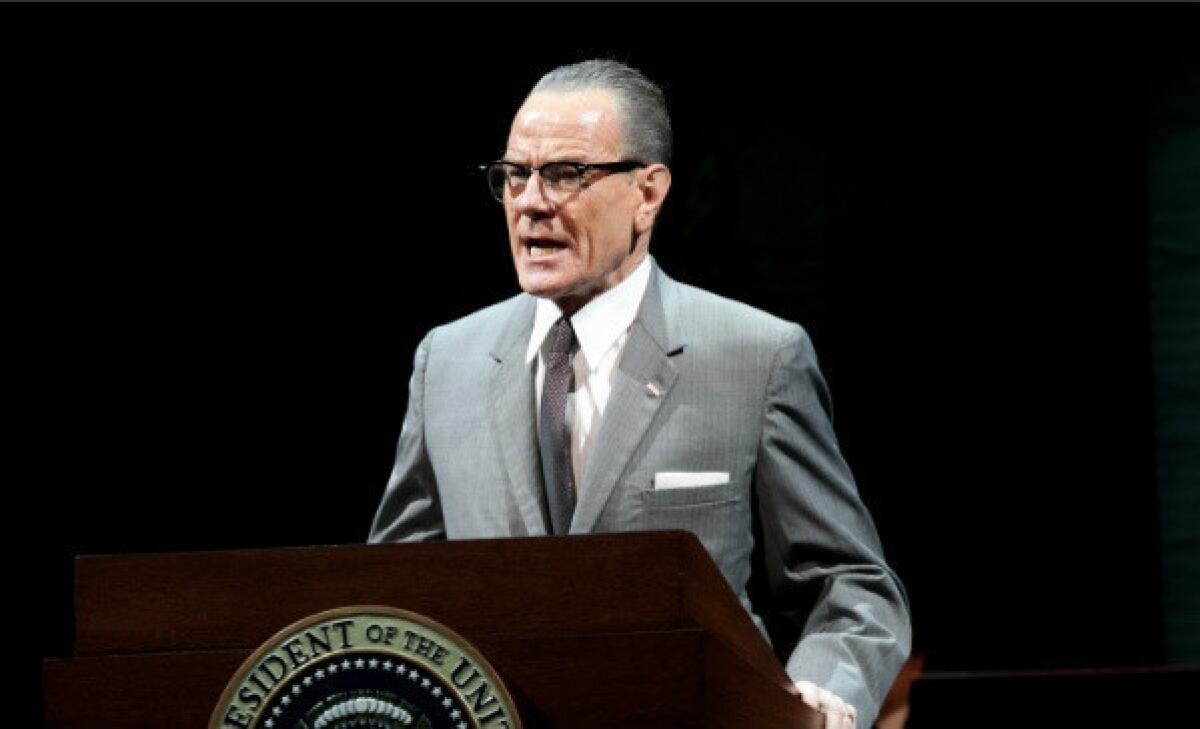 Cranston, in suit, narrow tie and horn rims, speaks from behind a podium that says "President of the United States."