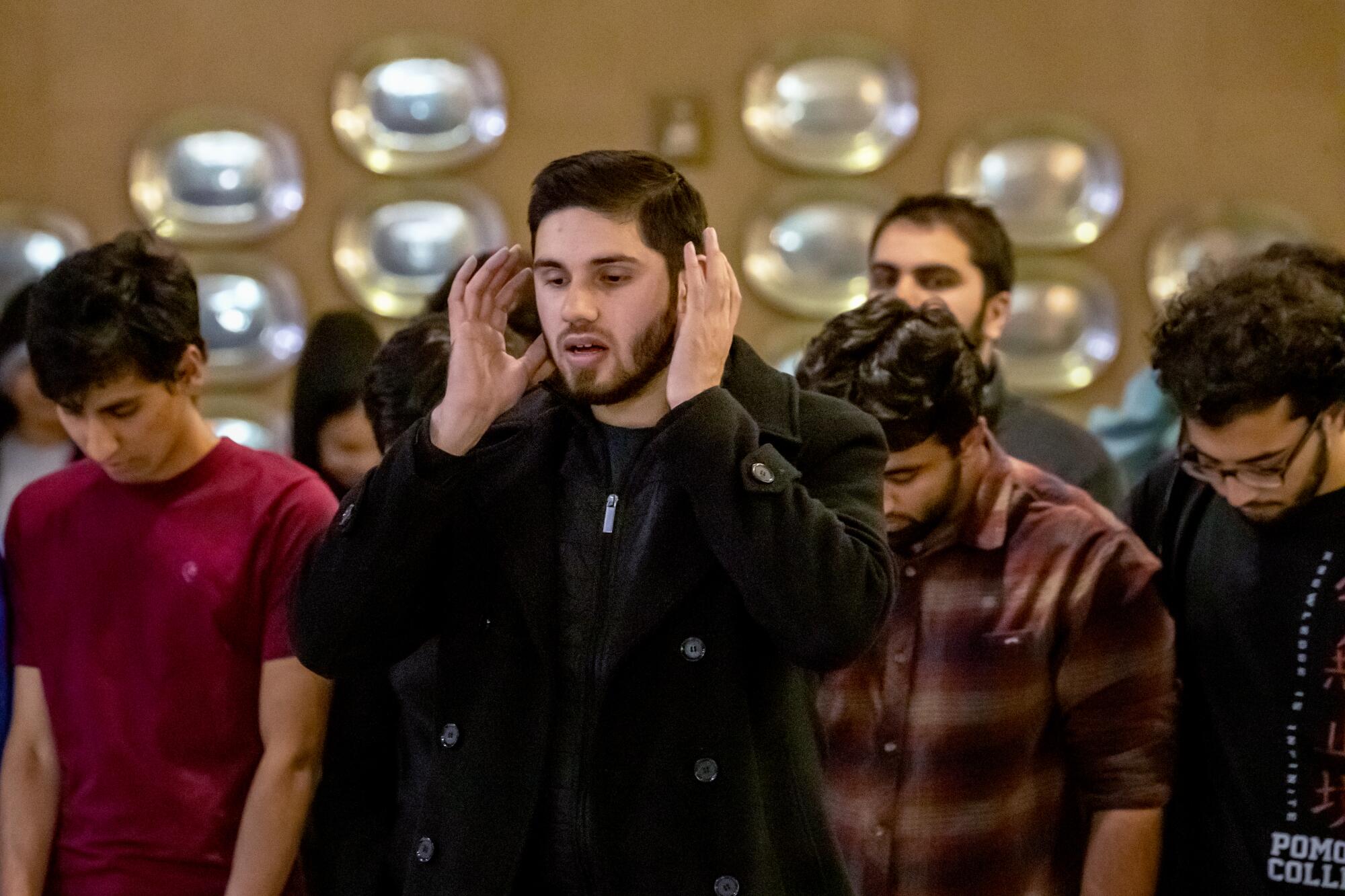 A small group of young Muslim men prays together.