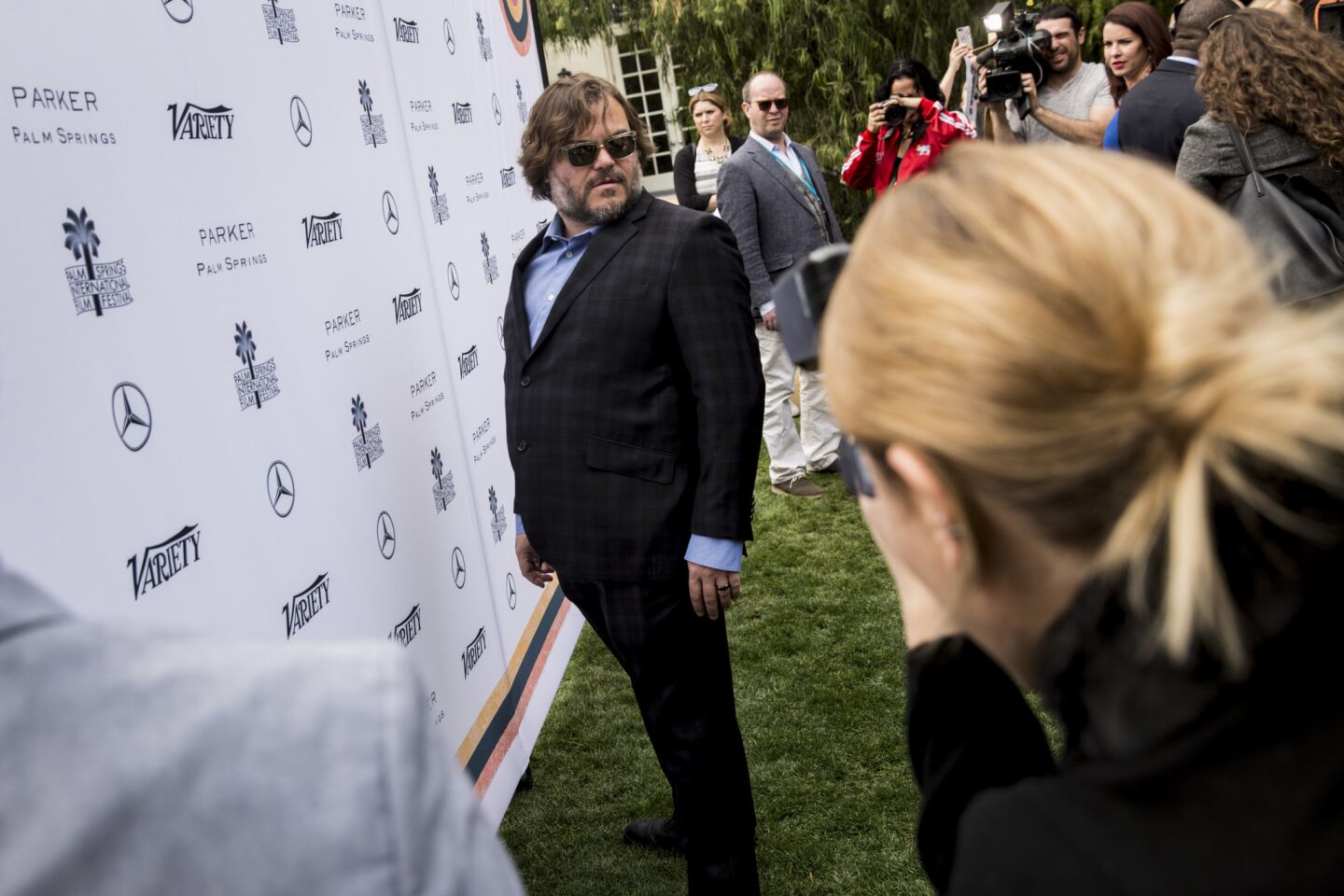 Actor Jack Black gives the photographers a different angle to shoot before the start of the Variety magazine luncheon.