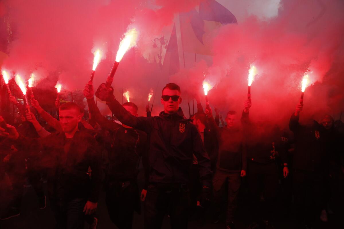 Members of the nationalist movements light flares during a rally marking Defense of the Homeland Day in Kyiv, Ukraine, on Monday.