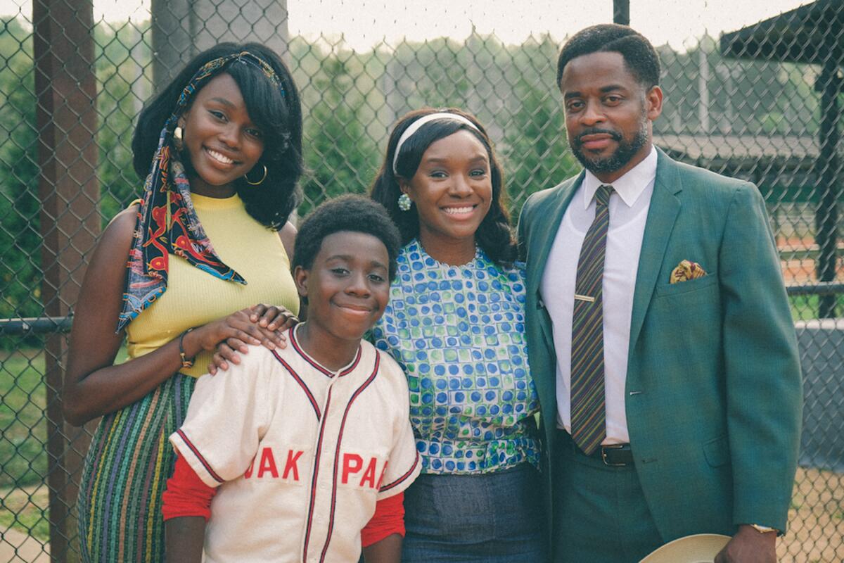 A Black family poses by a ball field in 1960s Alabama.