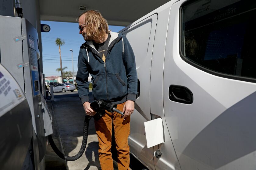 ORANGE, CA - MARCH 08: Travis Fago, of Orange, a small business owner, pumps gas at the Chevron gas station along Katella Ave. and Glassell on Tuesday, March 8, 2022 in Orange, CA. Fago paid $57.97 for 10.28 gallons of regular gasoline. "This is crazy," said Fago. The average price of a gallon of self-serve regular gasoline in Los Angeles County rose 8.9 cents today, its 30th record in 32 days. In Orange County average price rose 8.8 cents, its 29th record in 34 days. (Gary Coronado / Los Angeles Times)
