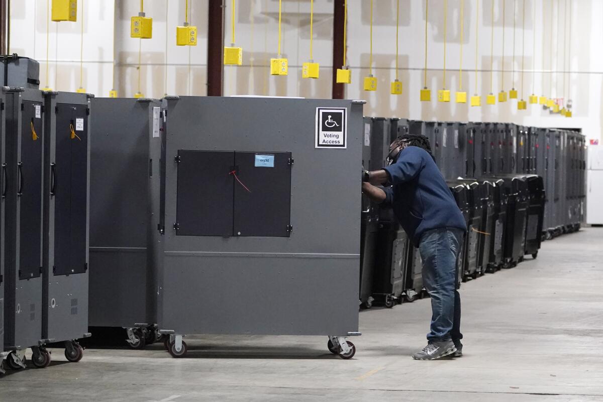 A person pushing a large machine into a row with several others in a bright storage area