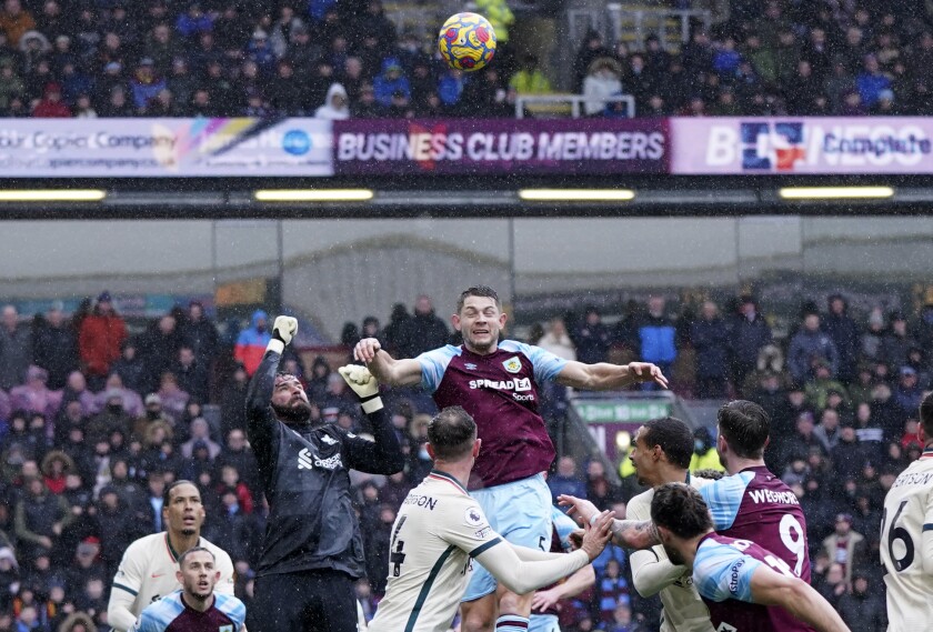 Liverpool's goalkeeper Alisson makes a save in front of Burnley's James Tarkowski during the English Premier League soccer match between Burnley and Liverpool at Turf Moor, in Burnley, England, Sunday, Feb. 13, 2022. (AP Photo/Jon Super)