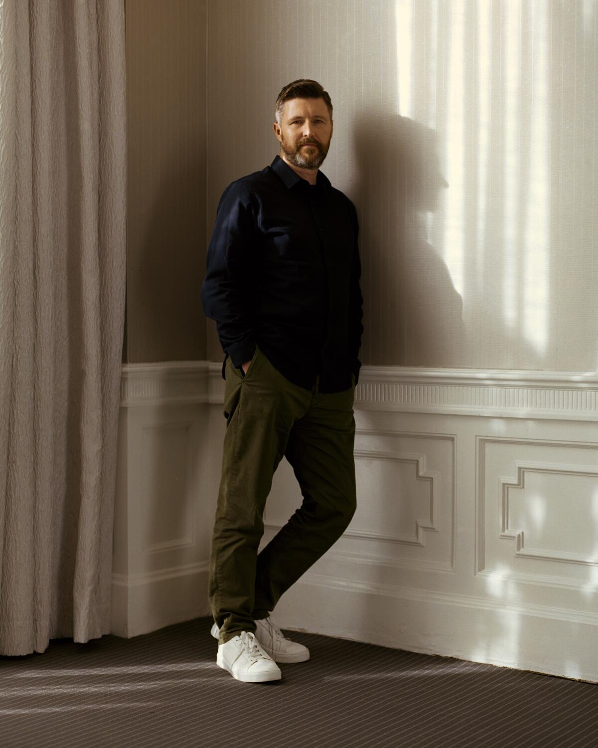 Andrew Haigh leans against a wall for a portrait.