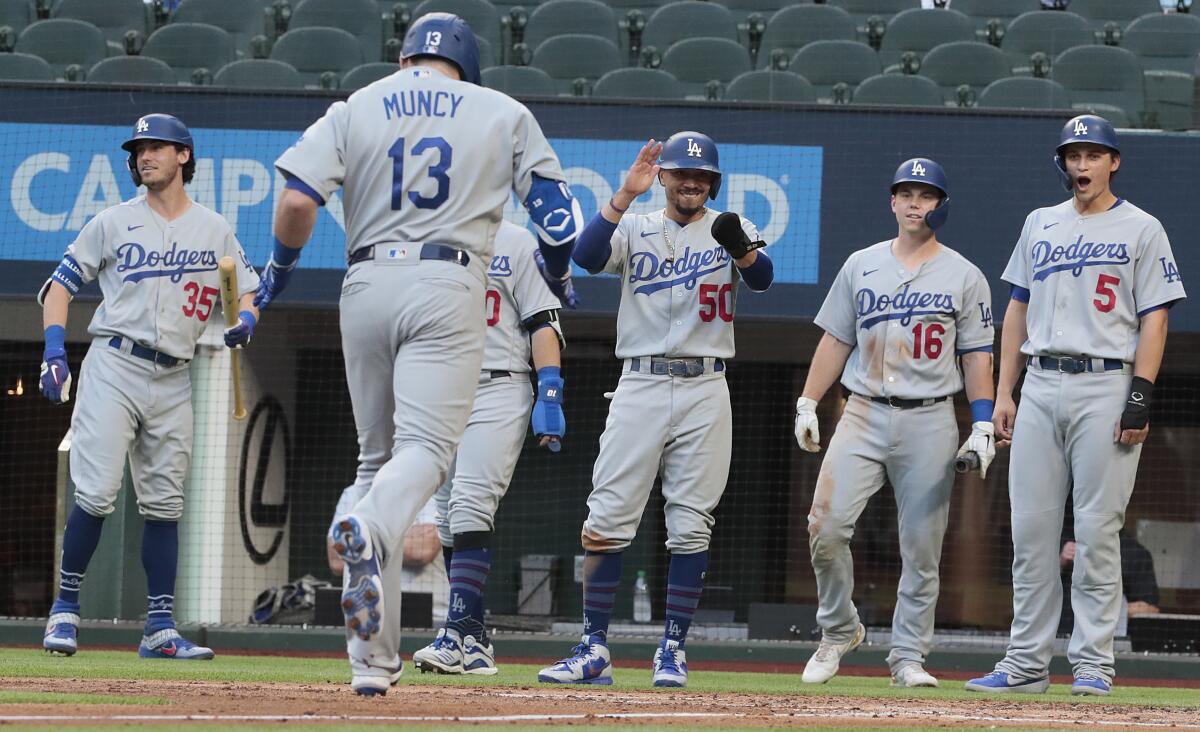 Dodgers players wait to celebrate with Max Muncy after his first-inning grand slam.