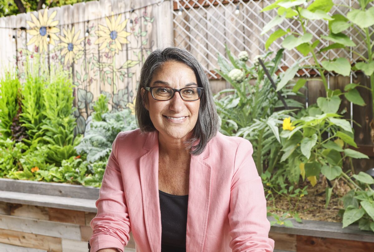 Mim Michelove poses for photos in her garden at her home