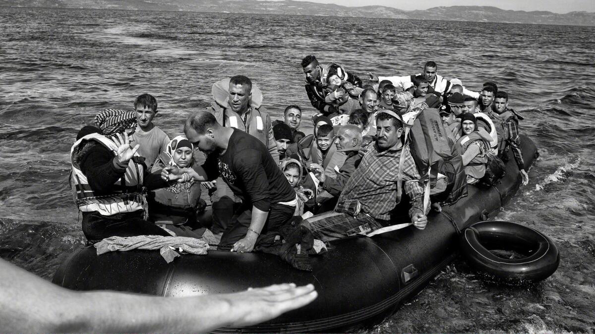 A rubber boat packed with refugees and migrants lands on the shoreline of Lesbos, Greece, after crossing the Aegean Sea from Turkey in 2015.