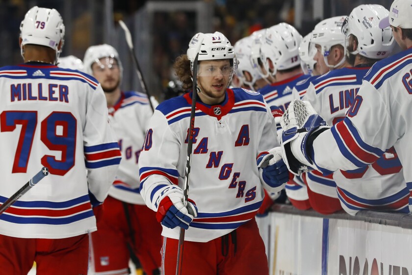 New York Rangers' Artemi Panarin is congratulated at the bench after scoring against the Boston Bruins during the third period of an NHL hockey game Friday, Nov. 26, 2021, in Boston. (AP Photo/Winslow Townson)
