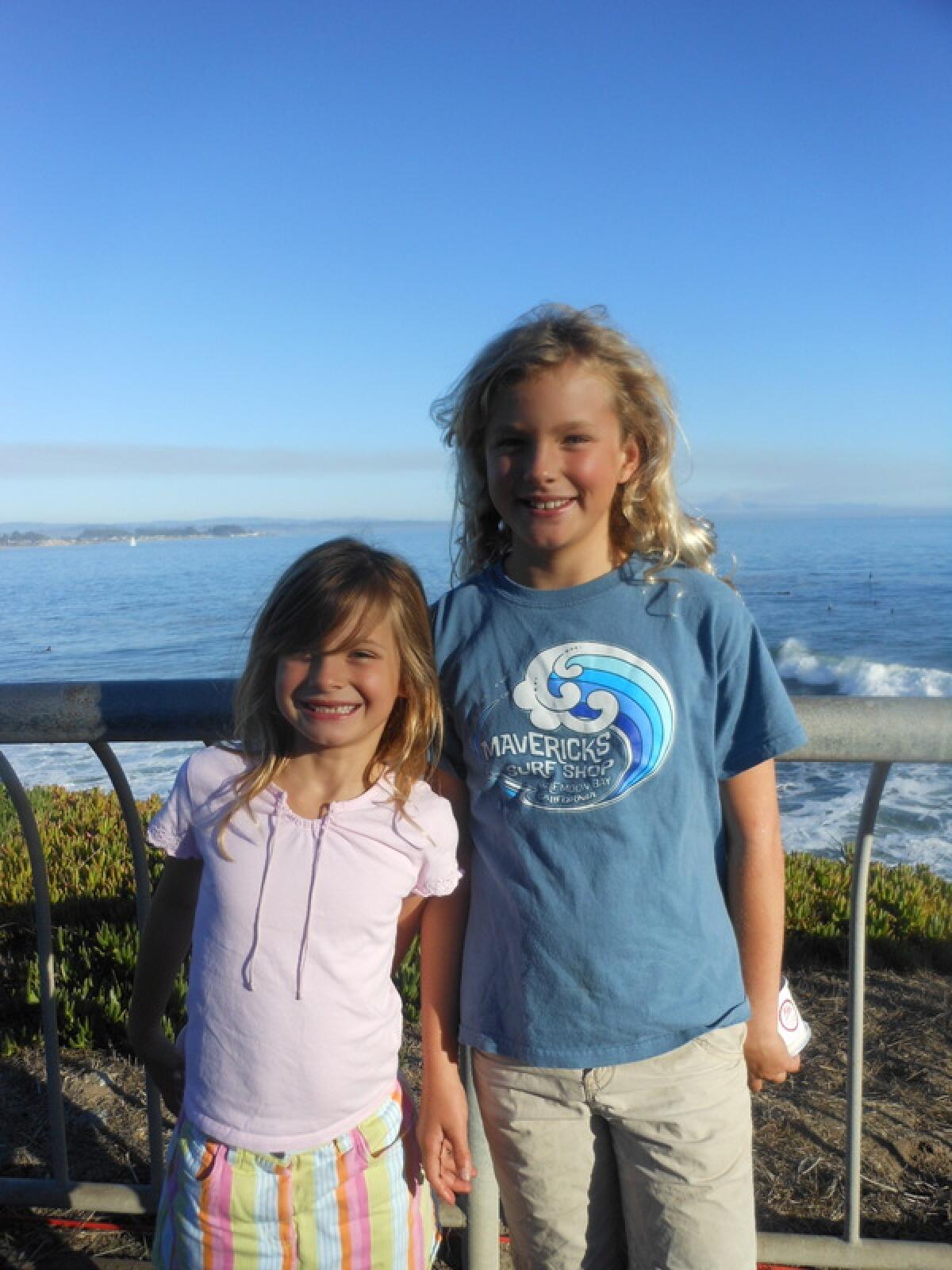Two girls standing in front of an ocean vista