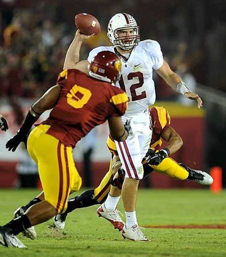 Stanford quarterback Andrew Luck looks to pass on the run before being sacked by USC defensive end Nick Perry on Saturday at the Coliseum.
