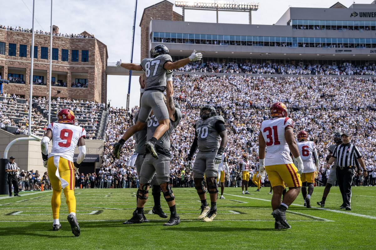 Colorado tight end Michael Harrison is lifted by offensive tackle Gerad Christian-Lichtenhan after scoring a touchdown.