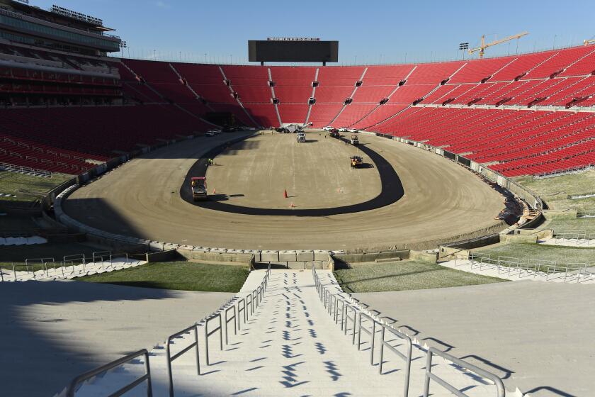 Los Angeles, California January 4, 2022: Work crews begin paving the track at the Coliseum in preparation for a NASCAR race, it's first ever at the Coliseum. (Wally Skalij/Los Angeles Times)