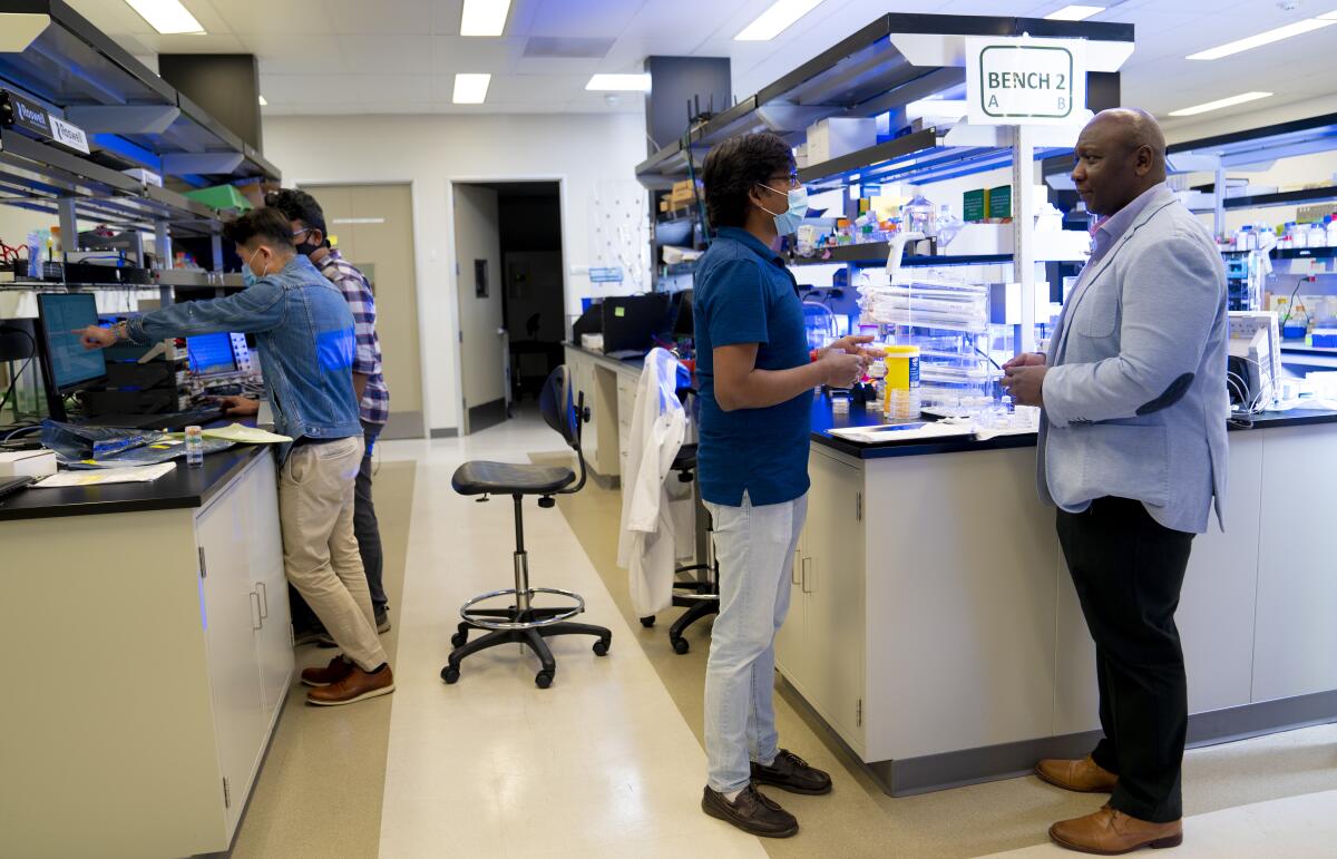 Founder and CEO of Roswell Biotechnologies in Sorrento Valley, Paul Mola (r) speaks with Roswell employees.